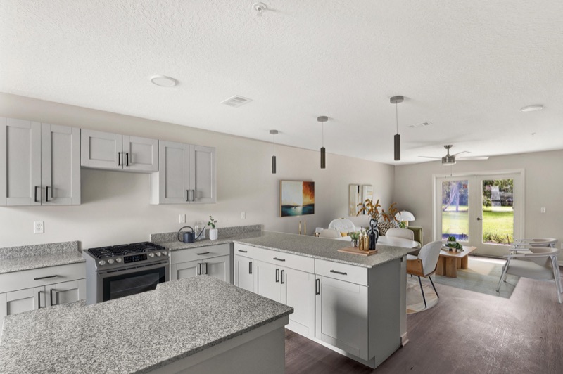 Kitchen with granite countertops and stainless gas range at Huntington Forest